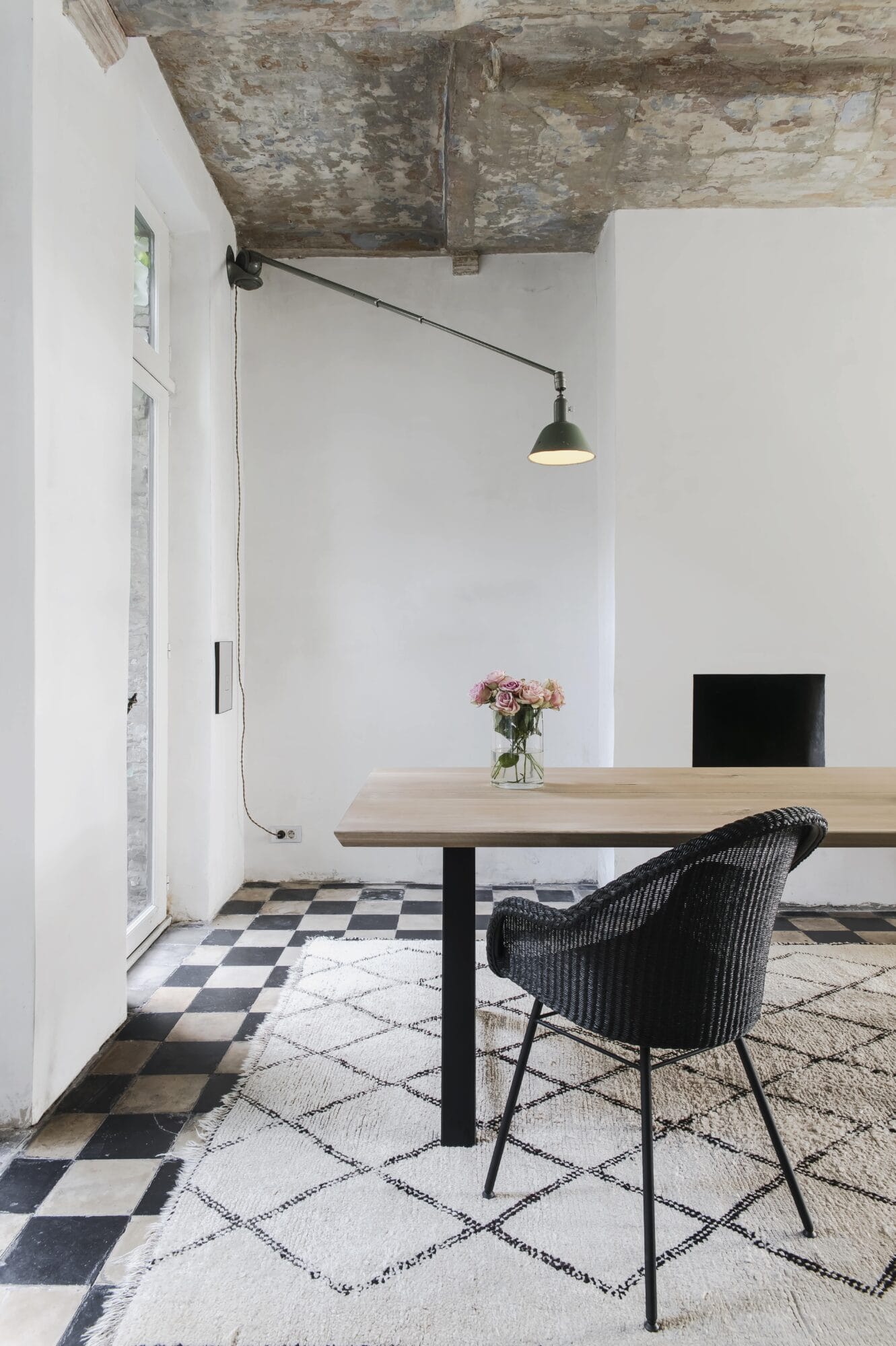 Une salle à manger avec un sol en damier noir et blanc agrémenté d'une chaise Avril.